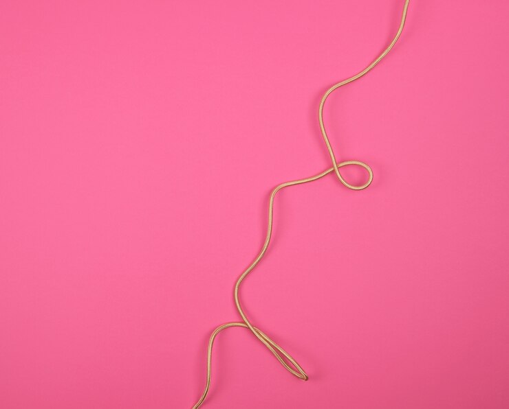 Foto cable trenzado dorado en un tejido sinuoso en color rosa.