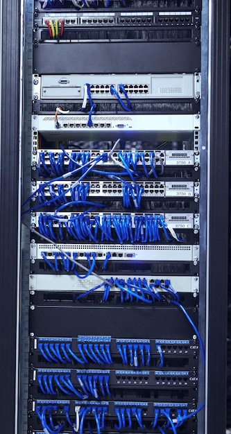 Cables azules alrededor Captura recortada del interior de una computadora con todo su cableado ubicado en una sala de servidores