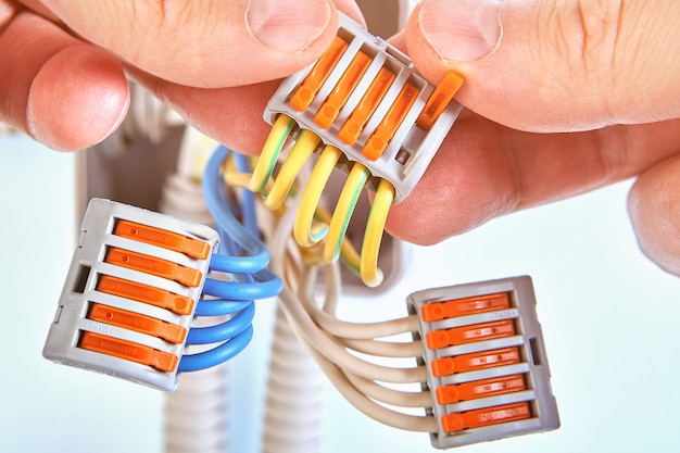 Los cables eléctricos de la caja de conexiones de plástico se conectan junto con el bloque de terminales enchufable.