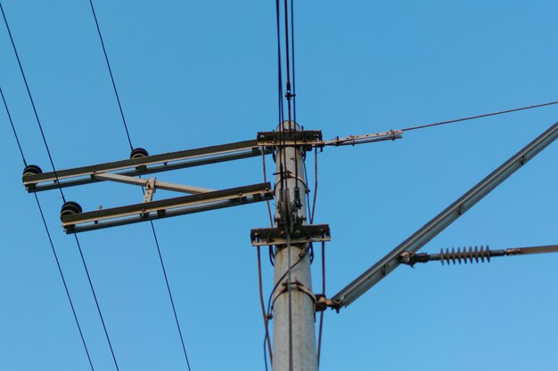 Cables eléctricos en un poste contra un cielo azul