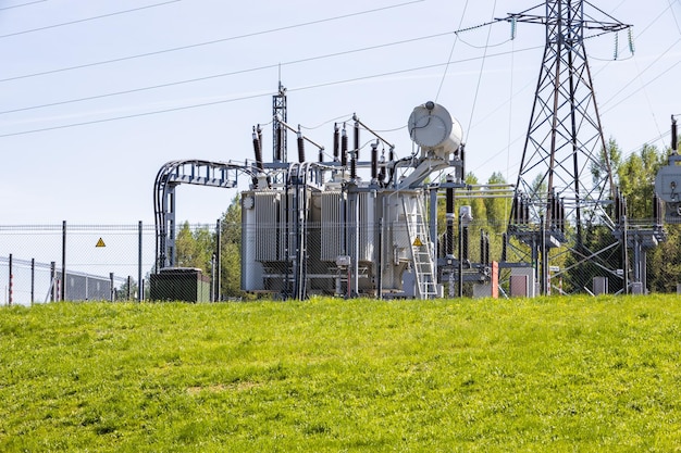 Foto cables de líneas eléctricas de transmisión de torres de electricidad de alto voltaje en la subestación de transformadores