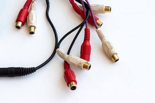 Año nuevo Decimal entregar Cables sucios con conectores de audio y video negros, rojos y blancos,  conector rca en una mesa de trabajo blanca rayada | Foto Premium