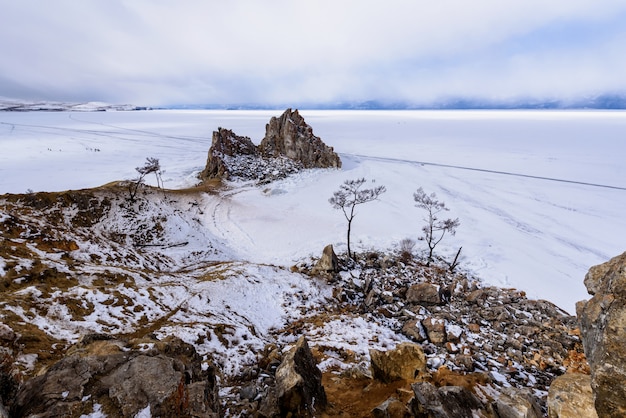 Cabo Burhan na rocha de Shamanka na ilha de Olkhon no dia ensolarado de março. Lago Baikal com belas nuvens