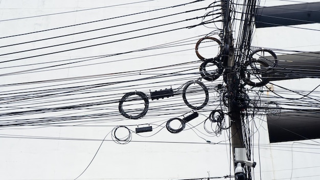Cabos de linha de sinal emaranhados no poste da linha caótica no poste elétrico na rua emaranhado fio elétrico na rua tailandesa