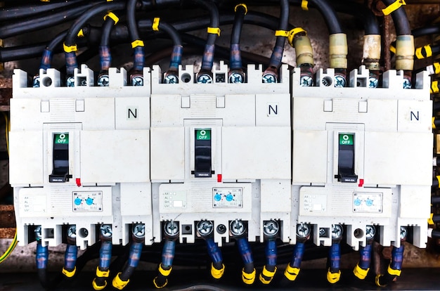 Cabos elétricos conectados a um bloco de distribuição com interruptores fechados