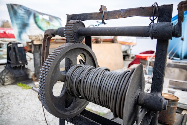 Cabrestante con una cuerda en un muelle con botes y botes contra el cielo