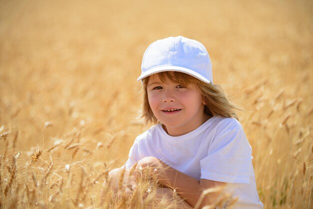 Cabrito en el campo de trigo. Niño niño en un campo de trigo en la luz del sol disfrutando de la naturaleza.