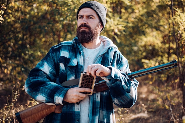 Foto caça na rússia. hunter com espingarda na caça. feche o retrato de caçador hamdsome. caça automática