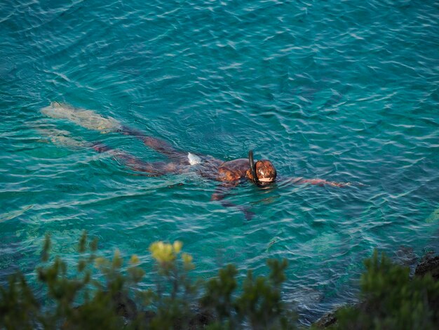 Caça submarina Natação, mergulho com snorkel em águas claras do mar das casas da vila da ilha vis, Croácia, durante um dia brilhante de verão