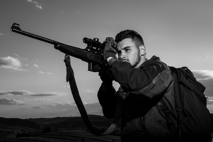 Foto caçador apontando rifle na floresta caçador com espingarda na caça caçador na temporada de caça de outono trac