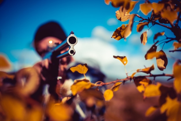 Caçador com rifle avistando alguns caçadores de veados com arma de espingarda no outono de caça