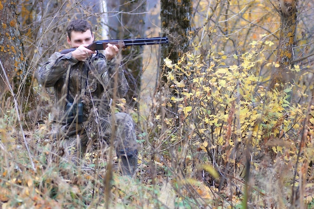 Caçador de homens ao ar livre na floresta de outono, caçando sozinho