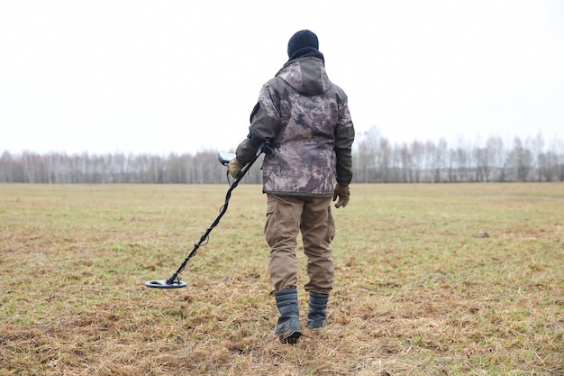 caçador de tesouros com detector de metais no campo