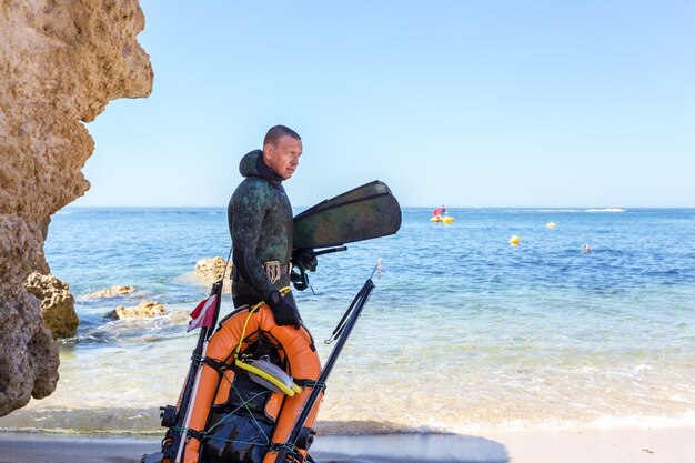 Caçador subaquático se preparando para mergulhar. Pesca subaquática no Oceano Atlântico.