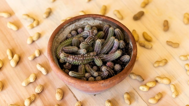 Un cacahuete en maceta y cacahuetes en una mesa de madera