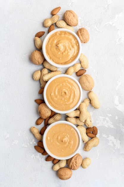 Cacahuetes, almendras y mantequilla de nueces sobre un fondo de hormigón