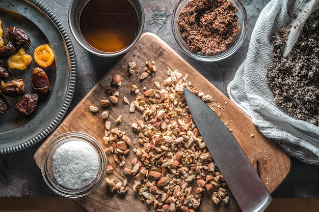 Cacahuetes triturados en el cuchillo del tablero e ingredientes para la granola