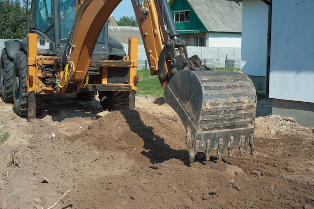 Caçamba de escavadeira fechada no fundo de um canteiro de obras Equipamento pesado de movimentação de terras Desenvolvimento do solo