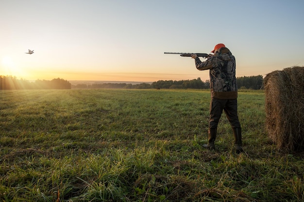 Foto caçando um faisão caçador com arma apontada para um faisão