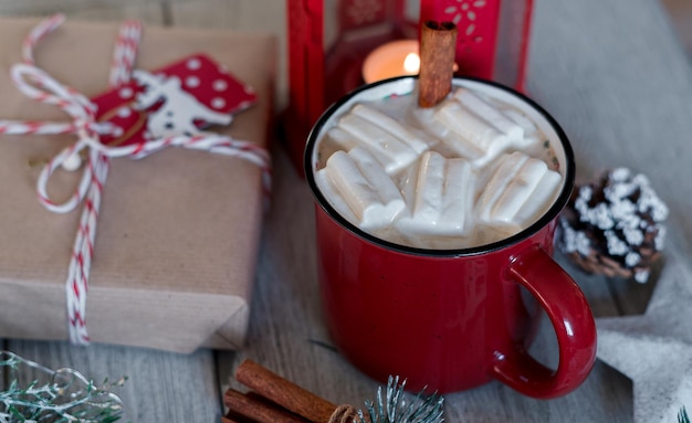 Cacao de bebida caliente de invierno con malvaviscos y canela o chocolate caliente picante en taza roja feliz