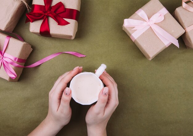 Cacao en las manos en el fondo de los regalos