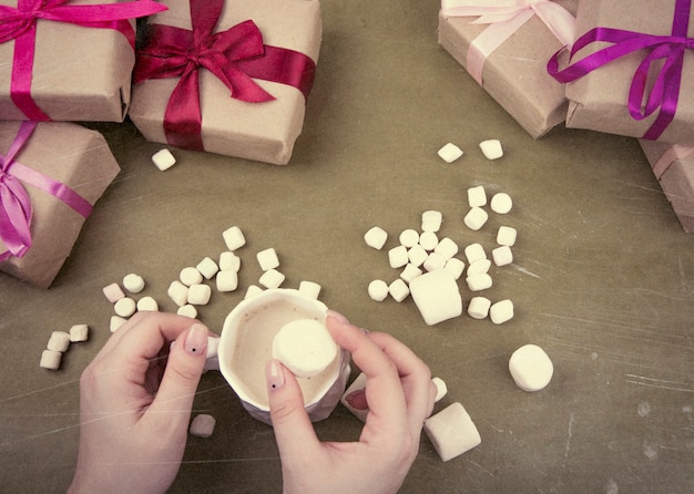 Cacao en las manos en el fondo de los regalos