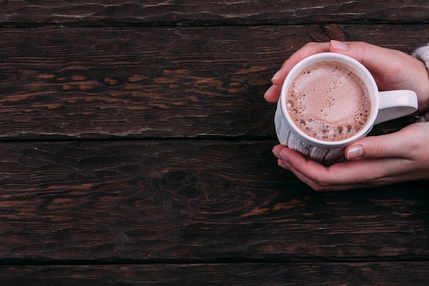 cacao en las manos sobre un fondo de madera