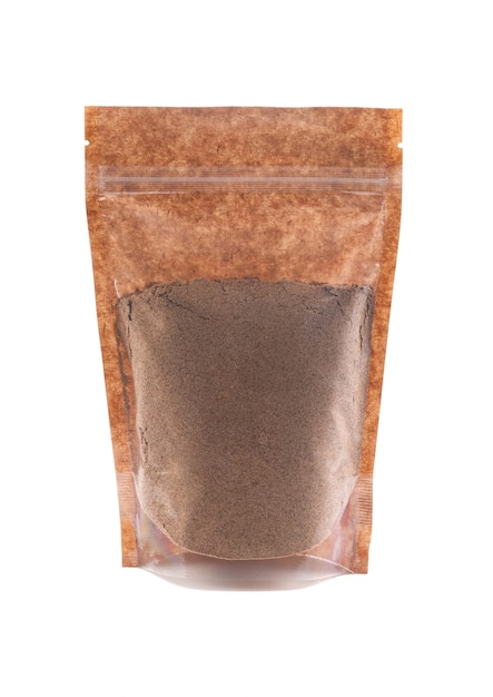 Cacao en polvo en una bolsa de papel marrón. Doy-pack con ventana de plástico para productos a granel. De cerca. Fondo blanco. Aislado.