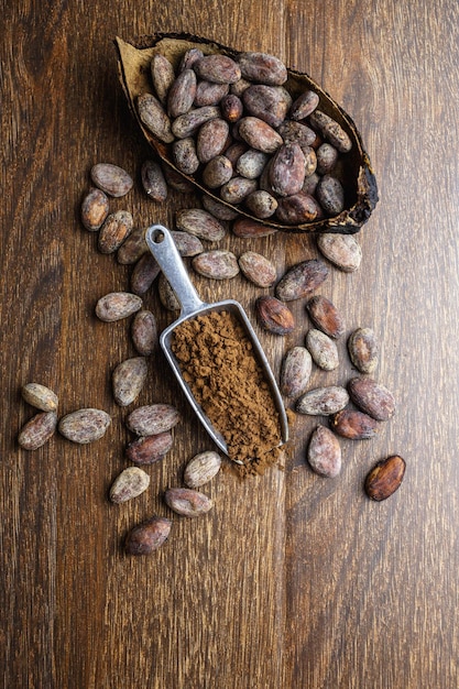 Cacao en polvo y cacao en grano sobre mesa de madera