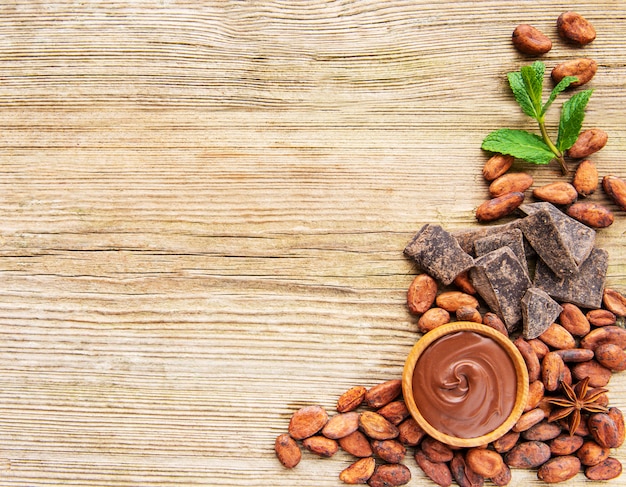 Cacao en polvo chocolate y frijoles sobre fondo de madera