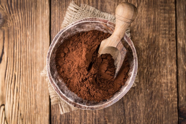 Foto cacao en polvo sobre fondo de madera