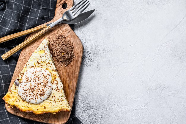 Foto caçarola de queijo cottage com chocolate em uma placa de corte. fundo branco. vista do topo. copie o espaço