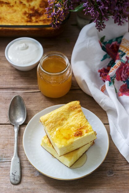 Caçarola tradicional de queijo cottage romeno ou moldavo com farinha de milho, servido com mel e creme de leite.