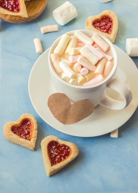 Cacau com marshmallows e um coração de biscoito. Foco seletivo.