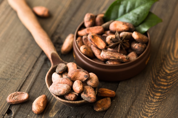 Cacau cru em tigela em uma mesa de madeira