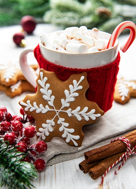 Cacau de Natal, biscoitos de gengibre e decorações. Fundo de madeira branco.