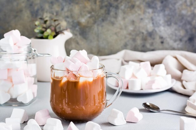 Cacau doce com marshmallows em forma de coração em um copo na mesa Bebidas caseiras