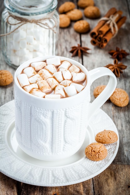 Cacau quente com marshmallows e biscoitos na mesa de madeira