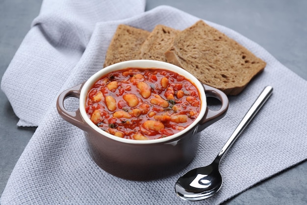 Cacerola de cerámica con frijoles de mantequilla italianos en la mesa de la cocina