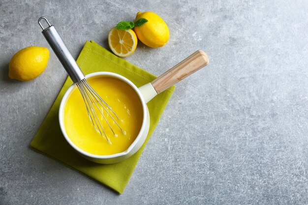 Cacerola con deliciosa cuajada de limón y batir en la mesa