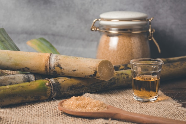 Cachaca ist der Name eines typischen alkoholischen Getränks, das in Brasilien aus Zuckerrohr hergestellt wird. Traditionelles Getränk aus Brasilien auf Holztisch