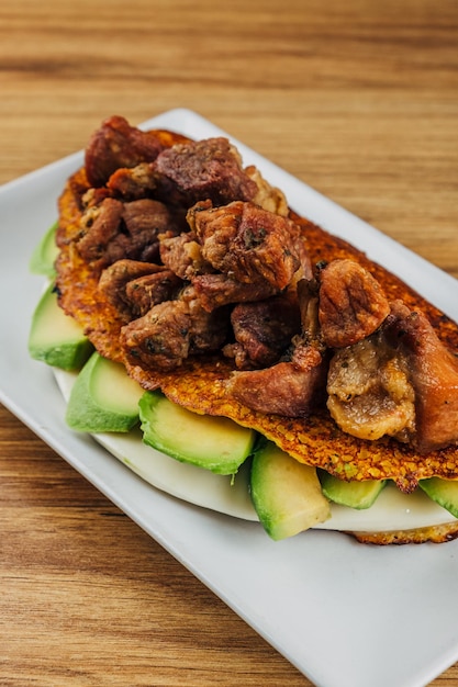 Foto cachapa venezolana de queso con cochino frito y aguacate