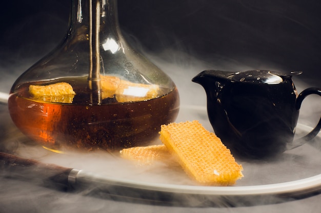 Foto una cachimba con una base de miel, un dulce sabor a cachimba, junto a los panales de panal