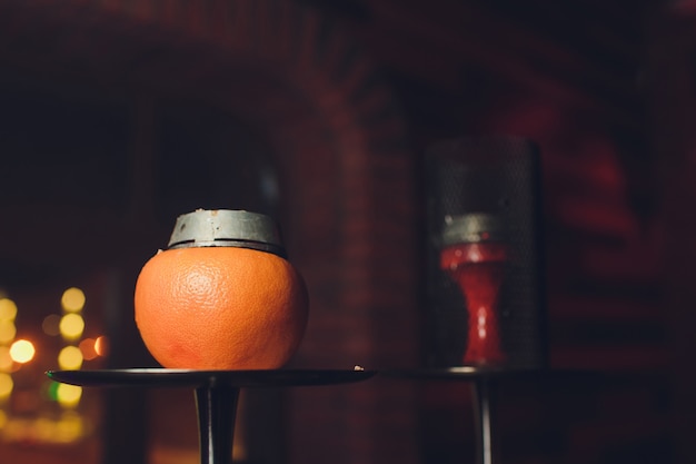 Cachimba de lujo con naranja. Cuenco exótico con fruta. Salón de la cachimba.