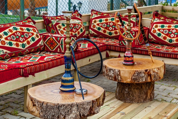 Cachimba en una mesa de madera y almohadas multicolores brillantes en el sofá, cachimba en Turquía