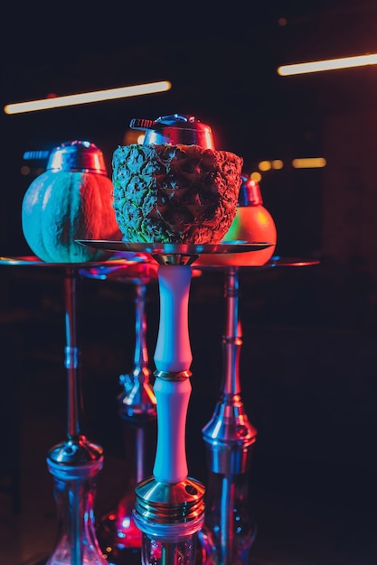 Foto cachimbo de água shisha vermelho com fumaça e faíscas vermelhas no fundo de arte de tijolos de mesa de madeira shisha concept