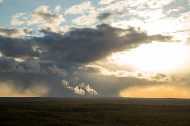 Foto cachimbos de energia térmicacéu dramático do pôr-do-sol aquecimento global planta paisagem pôr do sol problema de ecologia laranjaecologia ambiental poluição energia alternativa e conceitos de produção de gás natural