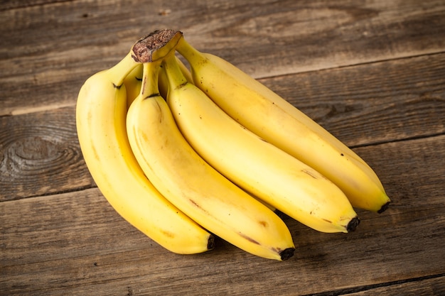 Cacho de bananas frescas na mesa de madeira