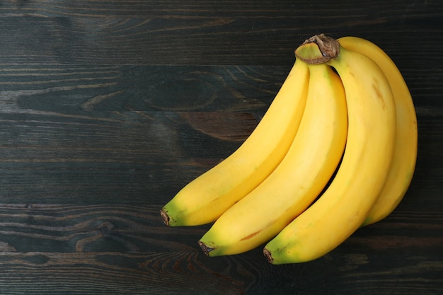 Cacho de bananas isolado na mesa de madeira marrom escuro