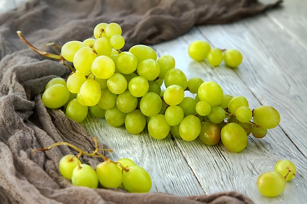 Cacho de uvas verdes em um fundo cinza de madeira